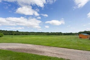 A rural landscape with a dirt path, green fields, and a wooden building. - Quiet Rural Escape w/ Indoor Heated Pool- Farmhouse Suite #4-20 mins to Wells (North Berwick)