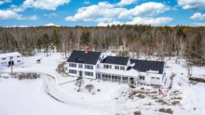 A large white house with a black roof, surrounded by snow-covered ground and trees. - The Green Room unit 4-Private Suite, Starry Skies -20 mins to Wells & Ogunquit (North Berwick)