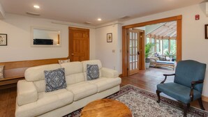 A living room with a sofa, a blue armchair, a wooden coffee table, and a patterned rug. - The Green Room unit 4-Private Suite, Starry Skies -20 mins to Wells & Ogunquit (North Berwick)