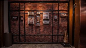 Un hall d’entrée avec un mur en briques et des tableaux encadrés.