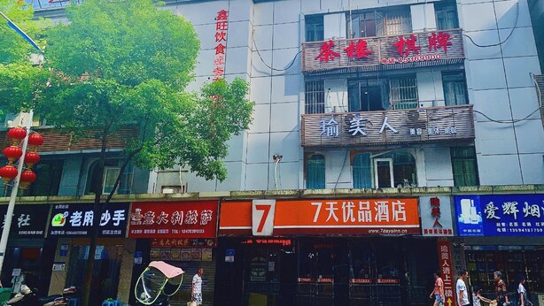 A multi-story building with various commercial establishments on the ground floor, including a hotel and a restaurant. - 7days Premium (Chongqing Tongliang Square) (Chongqing)