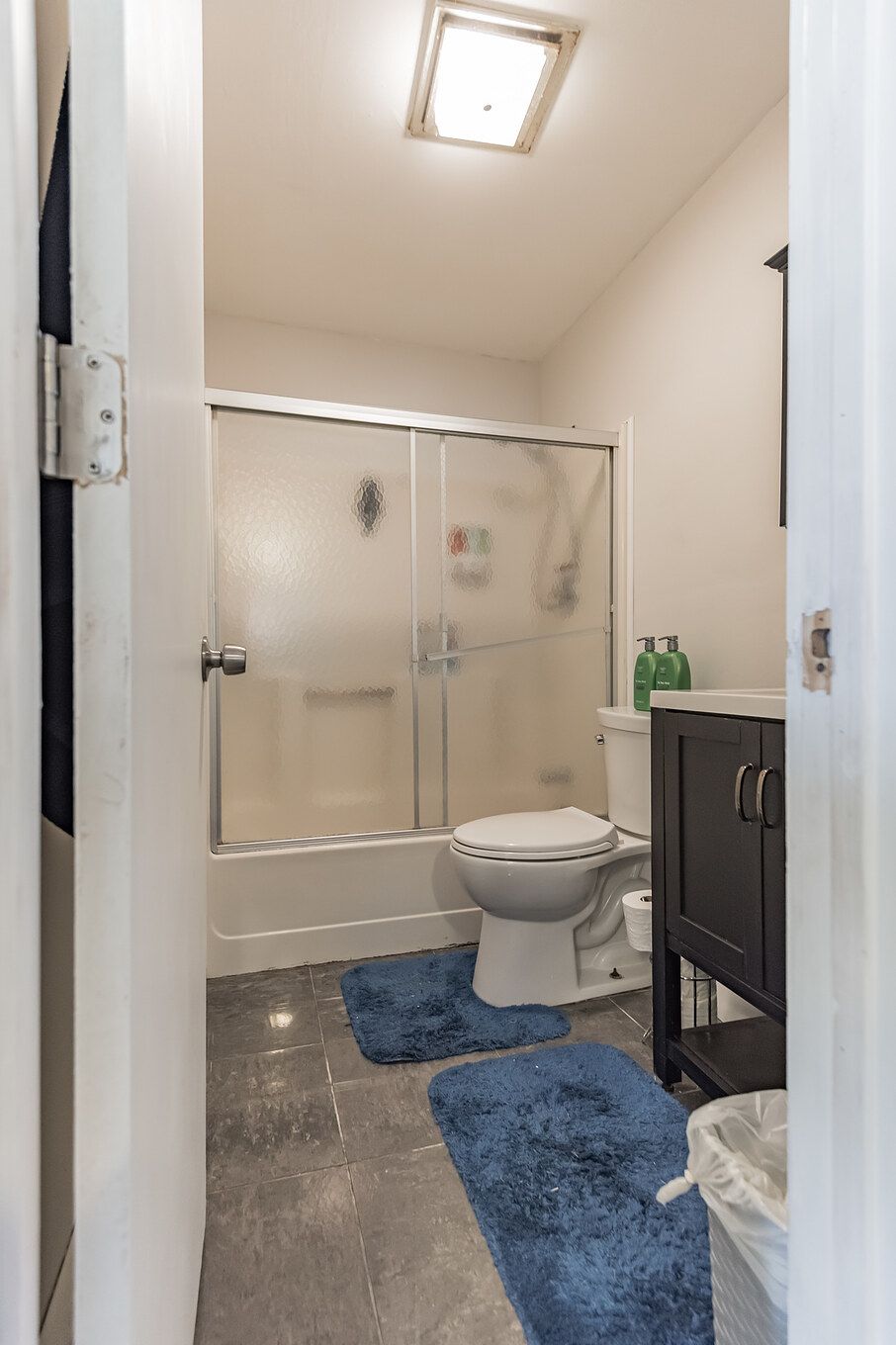 A bathroom with a shower, toilet, and sink.
