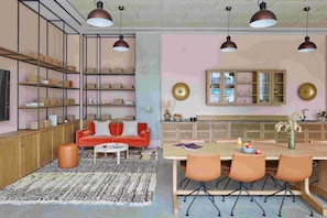 A modern living room with a sofa, coffee table, and dining area with chairs and a table.
