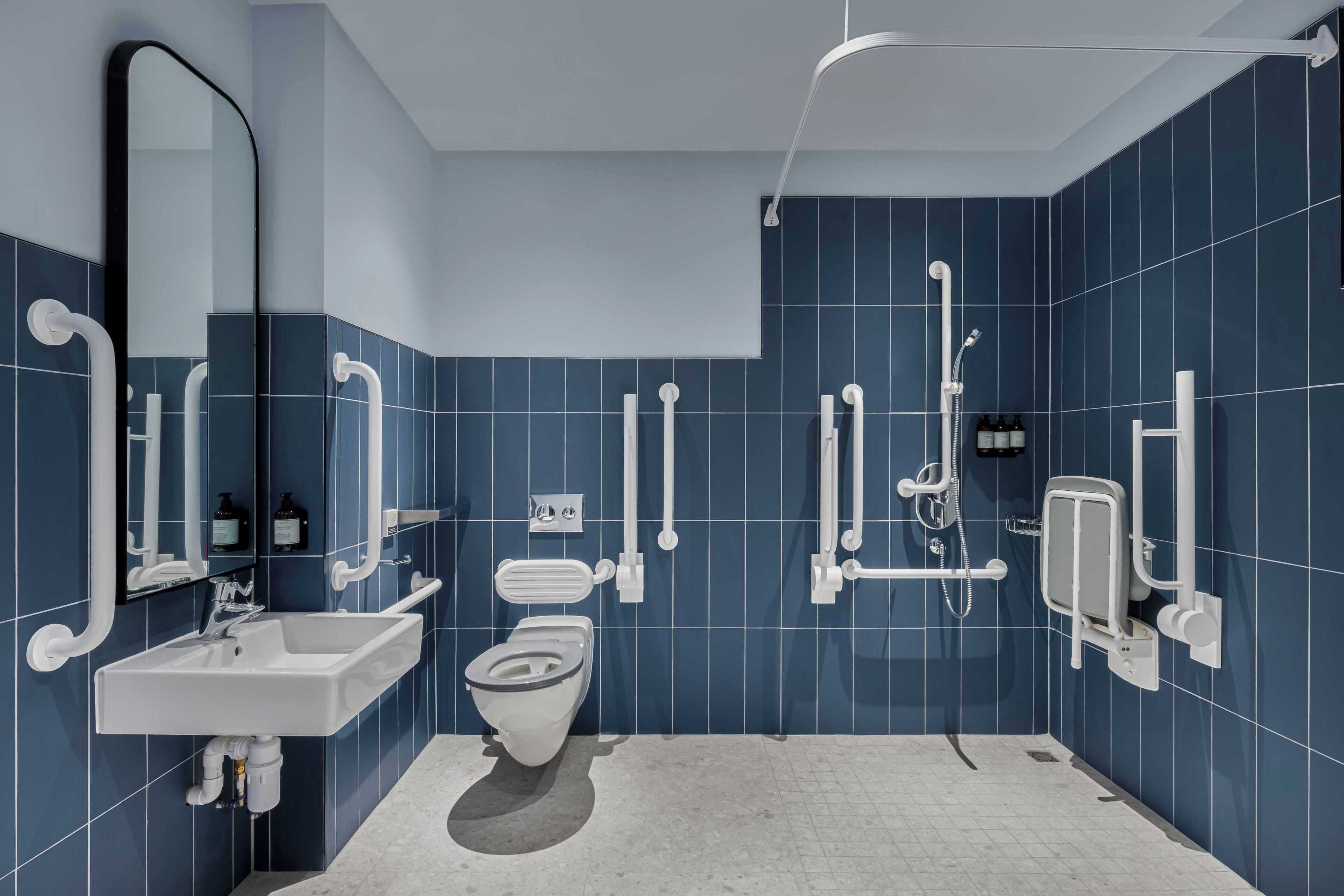 Een moderne badkamer met toilet, wastafel en douche.