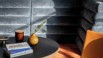 A modern living room with a black sofa, a round coffee table, and a few books.