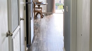 A hallway with a wooden floor, a ceiling light, and a door with a handle. - KING BED Oceanview 1BR Top Floor Villa (Hilton Head Island)
