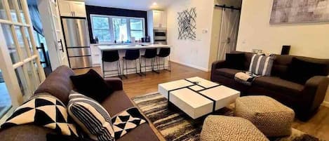 A modern living room with a sofa set, a coffee table, and a patterned rug.