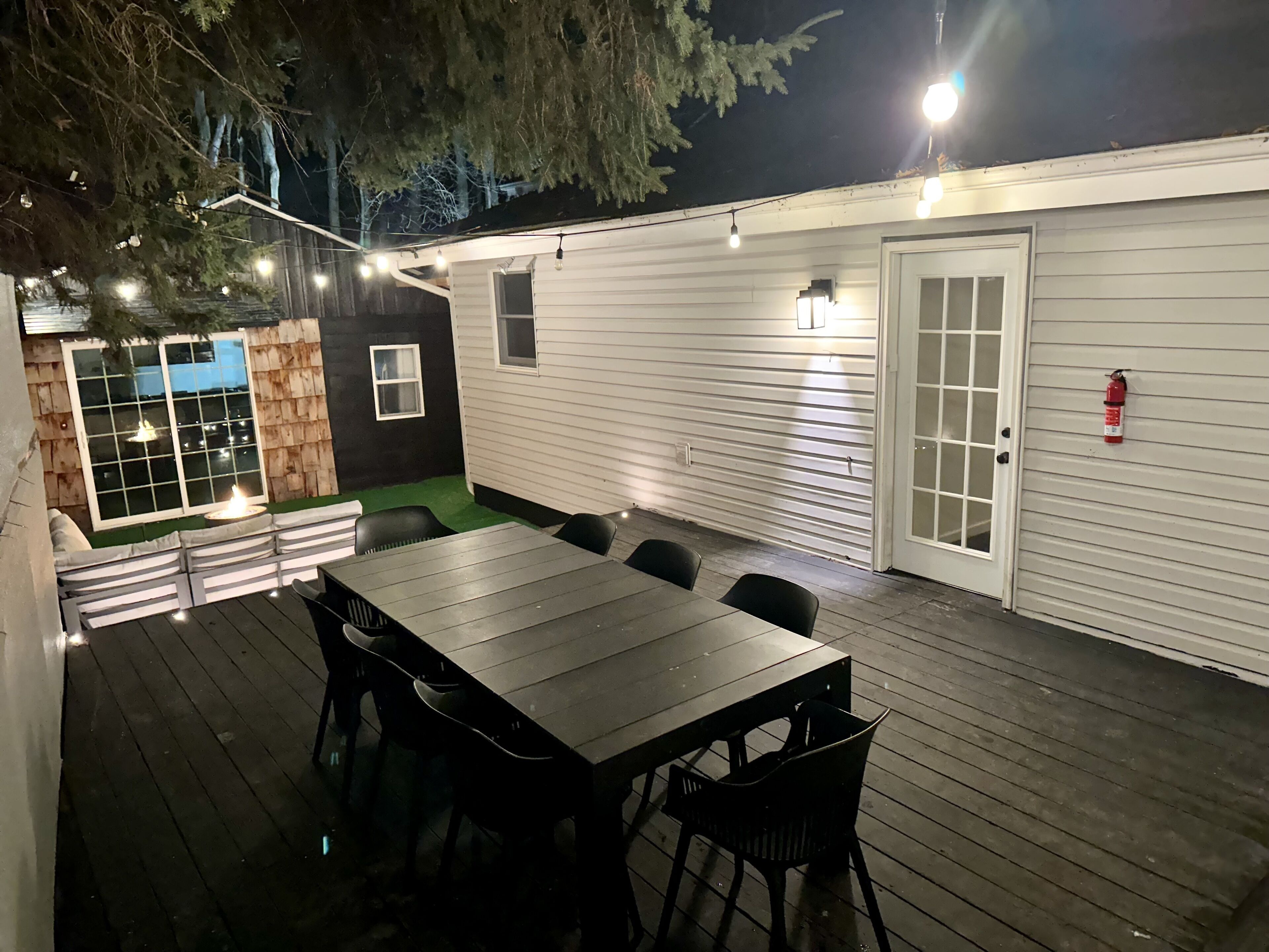 Eine Terrasse im Freien mit einem Holztisch und Stühlen, umgeben von einer Holzterrasse.