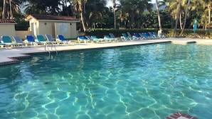 A clear swimming pool with blue lounge chairs and a brick border. - Golf View Rio Mar Villa (Río Grande)