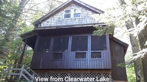 A wooden cabin with a balcony, located near a forested area. - Private lakeside cabin for those looking for peace and quiet in Brant Lake. (Brant Lake)