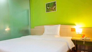 A hotel room with a bed, a nightstand, and a wall-mounted lamp. - 7 Days inn Chongqing (Chongqing)