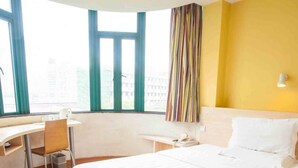 A hotel room with a bed, a desk, a chair, a window, and a curtain. - 7 Days inn Chongqing (Chongqing)