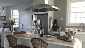 Una cocina moderna con una isla central, electrodomésticos de acero inoxidable y un salpicadero de ladrillo.
