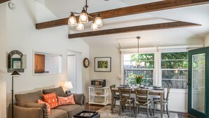 Una sala de estar acogedora con sofá, mesa de centro y comedor con sillas y una mesa.
