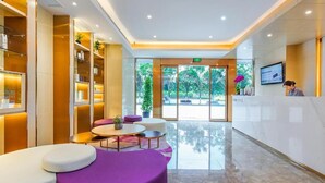 A hotel lobby with a reception desk, seating area, and large windows. - Lavande Hotel (Chongqing)