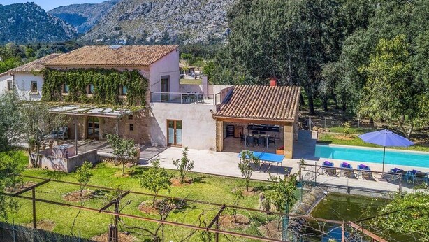 Une villa dotée d’une piscine, d’un patio couvert et offrant une vue sur un paysage montagneux.