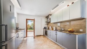 Une cuisine moderne avec des meubles gris, un four à micro-ondes et un évier.