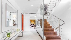 A modern interior with a staircase, a hallway, and a dining area. - Villa Cavall, Magnificent house 200 meters from the beach (Cala Sant Vicenç)
