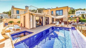 A two-story building with a swimming pool, outdoor seating, and a covered patio area. - Villa Cavall, Magnificent house 200 meters from the beach (Cala Sant Vicenç)