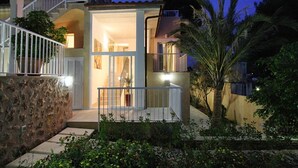 A modern house with a stone facade, a balcony, and a staircase leading to an upper level.