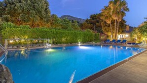 A swimming pool with lounge chairs and a view of trees and a mountain in the background. - Villa Formosa, One of the most loved properties. Impressive garden (Cala Sant Vicenç)