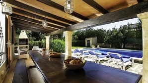 An outdoor bar area with a pool view, wooden beams, and lounge chairs. - Villa Barraca, Peace and relax at 10m. walking to Puerto Pollensa (Port de Pollença)