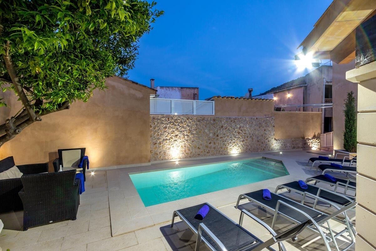 Ein Swimmingpool mit Liegestühlen und einer Steinmauer.