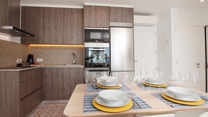 A modern kitchen with wooden cabinets, a built-in oven, and a stainless steel refrigerator. - Sivella Apartament, Front-line studio located in Puerto Pollensa (Port de Pollença)