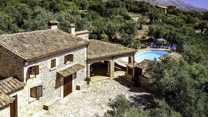 A stone building with a pool and lounge chairs. - Villa Alordes, Newly renovated house with mountain views (Pollença)