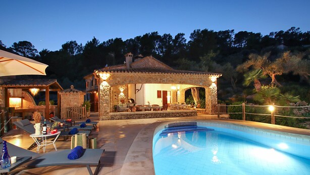 A poolside area with lounge chairs, a small pool, and a stone building with a patio. - Villa Alordes, Newly renovated house with mountain views (Pollença)
