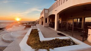 A modern building with a curved roof and multiple balconies overlooking a landscaped area. - Casa San Miguel Beachfront House (Puerto Peñasco)
