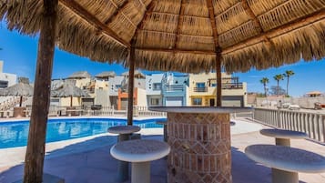 Relax by the serene pool surrounded by shaded seating areas and stone tables.