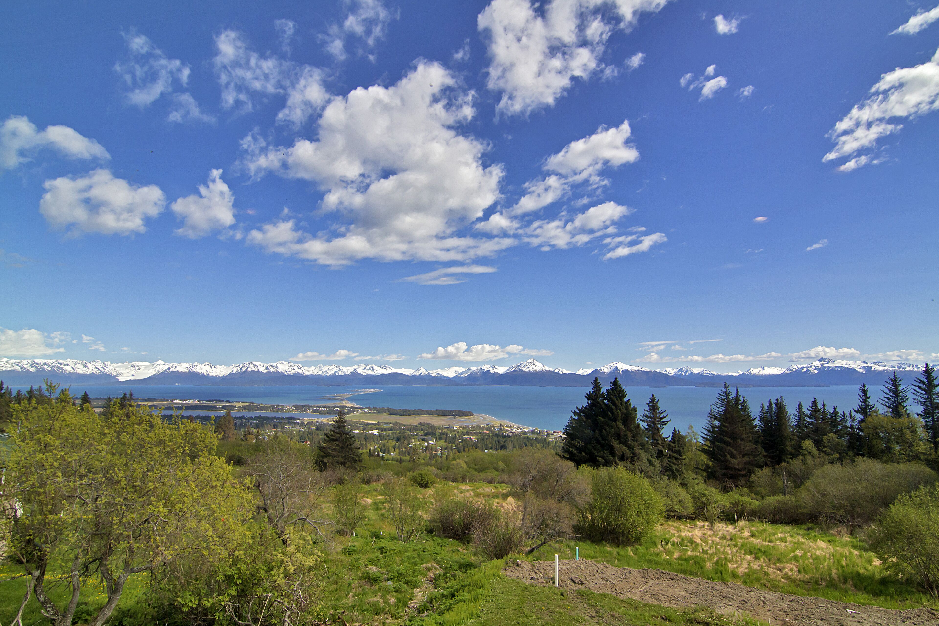 A mountainous landscape with a clear sky and a view of a lake.