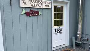 Un bâtiment avec une enseigne indiquant « Entrée de Moose's View » et un panneau d’accueil représentant un élan et des arbres.