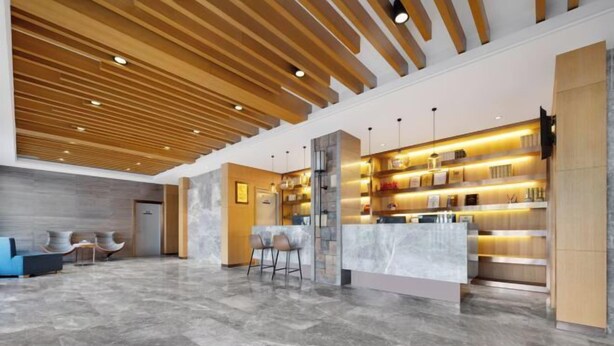 A modern lobby with a marble floor, wooden ceiling, and a reception desk with a glass partition. - Raspberry Boutique Hotel (Lanzhou)