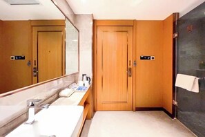 A hotel bathroom with a large mirror, a sink, and two wooden doors. - Raspberry Boutique Hotel (Lanzhou)