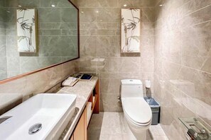 A modern bathroom with a large bathtub, toilet, and a small trash bin. - Raspberry Boutique Hotel (Lanzhou)