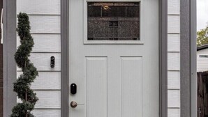 A white front door with a small window above it, a mailbox, and a potted plant to the left. - The Studio at Cleveland Park 2 bedroom 2 bathroom Near Lower Broadway (Nashville)