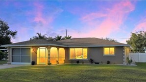 A two-story house with a garage, a front porch, and a well-maintained lawn. - Casa Florida, Pet-friendly, Child-friendly  (Port Charlotte)