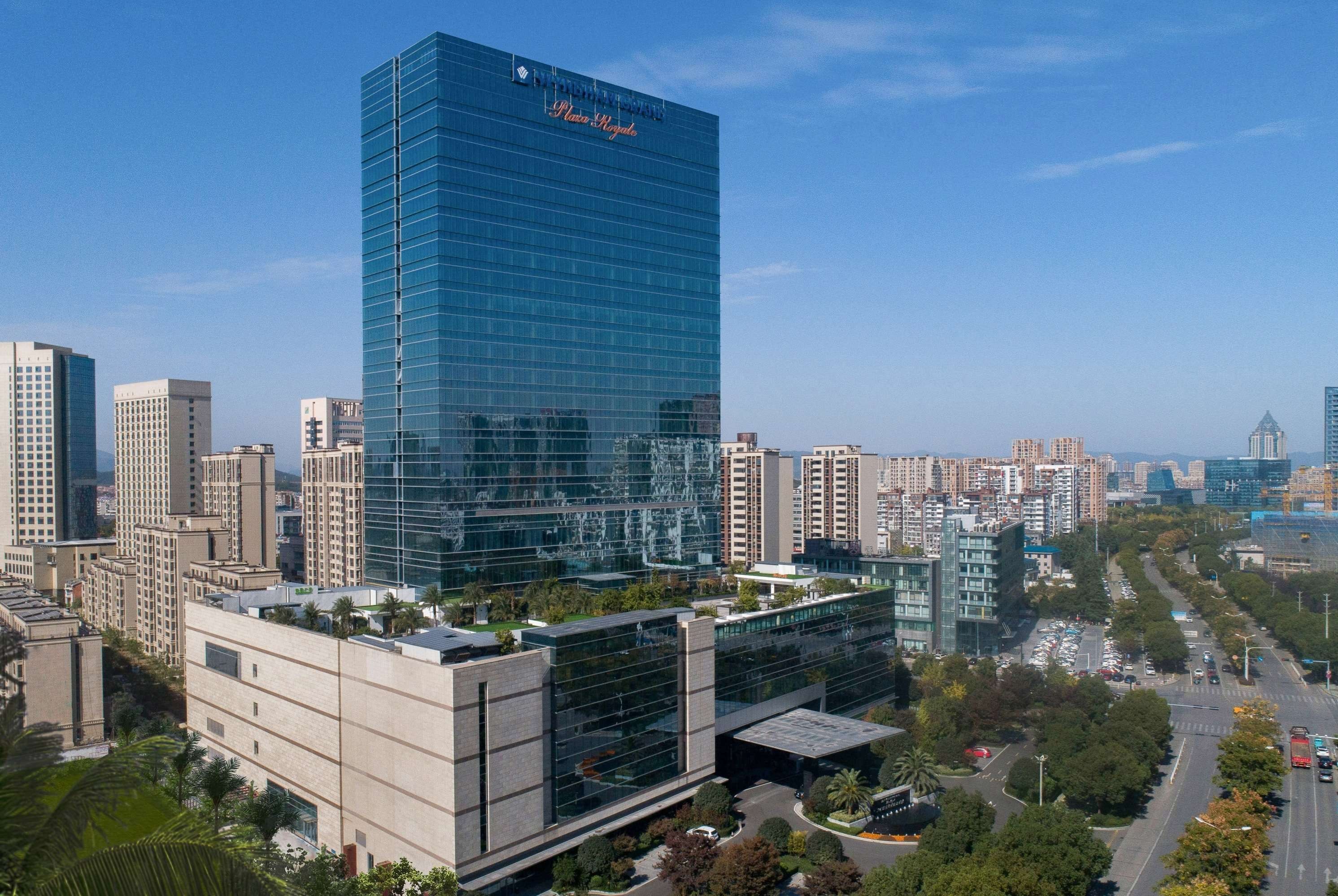 Un moderno edificio de gran altura con fachada de vidrio y un letrero que dice 'Plaza Royale'.