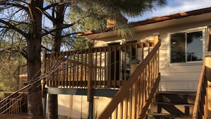 A wooden deck with a staircase leading to a house with a window. - MileHi Vacation Home (near DIA, pet friendly, has a baby crib) (Aurora)