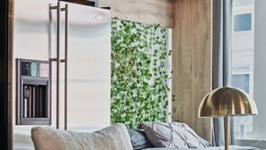 Een moderne slaapkamer met een groene bank, een houten hoofdbord, een nachtkastje en een lamp.