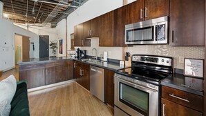 Een moderne keuken met roestvrijstalen apparatuur, houten kastjes en een groot eiland.