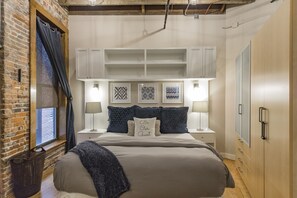 Relax in a serene bedroom with a large bed, nightstands, and artwork adorning the walls.