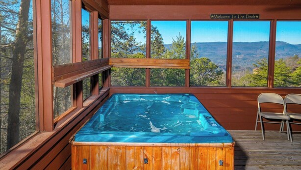 A hot tub in a wooden cabin with large windows overlooking a mountainous landscape. - Steamy Soaks with Scenic Views, Fireside Chats, Outdoor Showers & Game Nights - Jackson's Cabin (Sevierville)