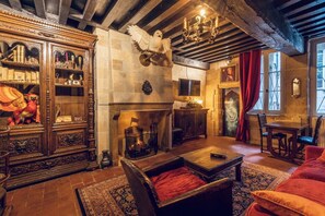 Ein traditionell eingerichteter Raum mit Kamin, Holzmöbeln und einer Kandelaber.