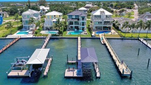 Une propriété située au bord de l’eau, comprenant plusieurs maisons, un quai et une piscine.