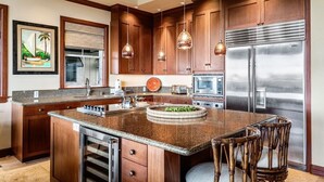 Una cocina moderna con encimeras de granito, electrodomésticos de acero inoxidable y armarios de madera.