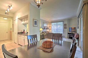 Relax in this spacious living area with a dining table for four, a modern kitchen, and a comfortable seating area.