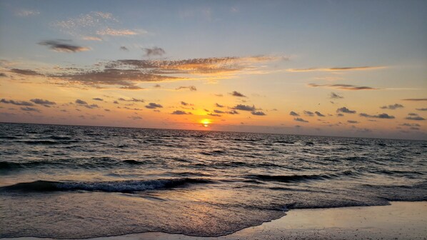 Enjoy the tranquil beach scene with gentle waves lapping at the shore.